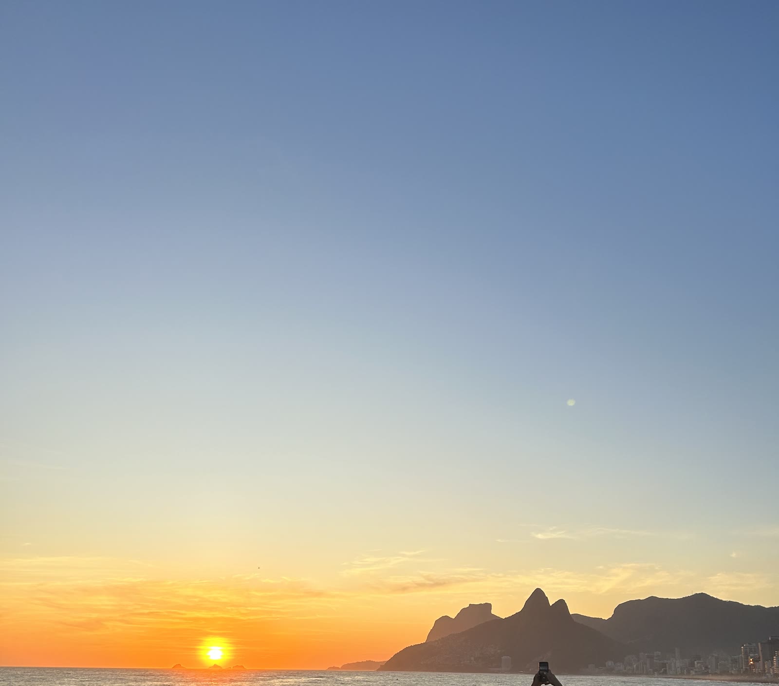 O pôr do sol aplaudido no Arpoador, com o Morro Dois Irmãos ao fundo.